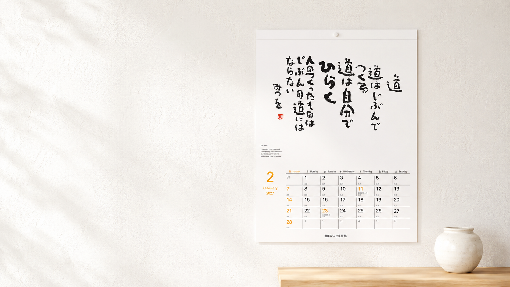 明るい白壁に、2月の作品『道』を掲載したレギュラーカレンダーが掛けられている様子